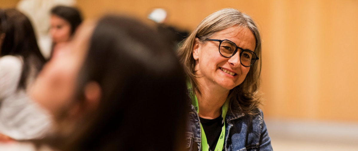 A woman smiling in a meeting.
